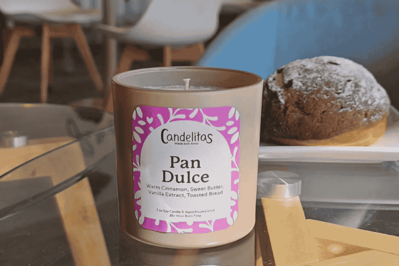 Pan Dulce scented soy candle next to a sweet bread pastry.